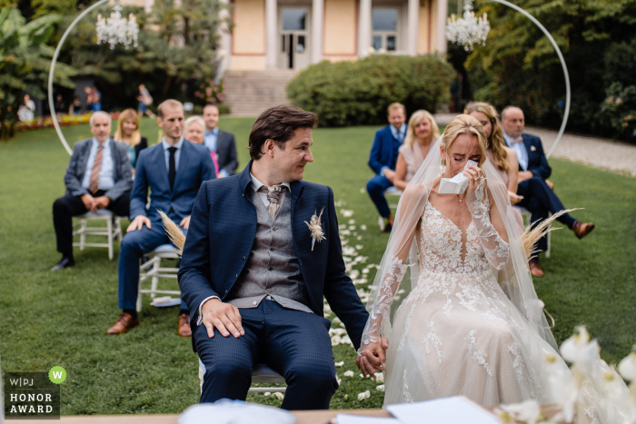 Cette photo de photojournalisme de mariage en Italie est un exemple de premier ordre de ce à quoi ressemble la photographie de mariage candide et non traditionnelle du lac Majeur, en tant que mariée comme un moment émouvant lors de la cérémonie de la Villa Giuila