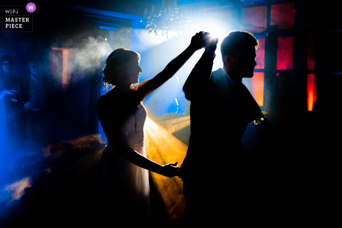 A Gorizia documentary style wedding image showing a moment at Castelvecchio Sagrado of the First dance for the bride and groom under DJ lights A Gorizia documentary-style wedding image showing a moment at Castelvecchio Sagrado of the First dance for the bride and groom under DJ lights
