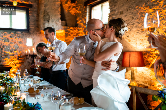 Udine, fotógrafo de documentários de casamento da Itália, no La Brunelde em Fagagna, criou esta imagem da noiva e dos noivos Beijo de recepção