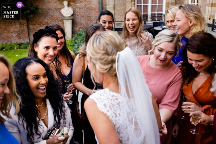 Um documentário holandês fotógrafo de casamento em Markiezenhof em Bergen op Zoom tirou esta foto da noiva com seus amigos após a cerimônia