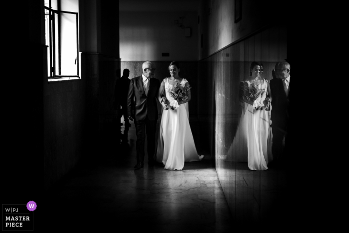 Um fotógrafo de documentários de casamento renomado da Itália em Napoli criou esta imagem em BW enquanto a noiva sai de casa