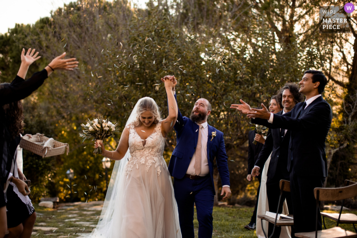 Een Italiaanse trouwfoto in documentairestijl met een moment in Parrano, Umbrië, met het paar en hun buiten Exit from the Ceremony