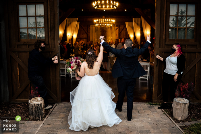 A top Nebraska wedding photojournalism example from a beautiful Roca Berry Farm wedding venue in Nebraska as The bride and groom are introduced into the reception 