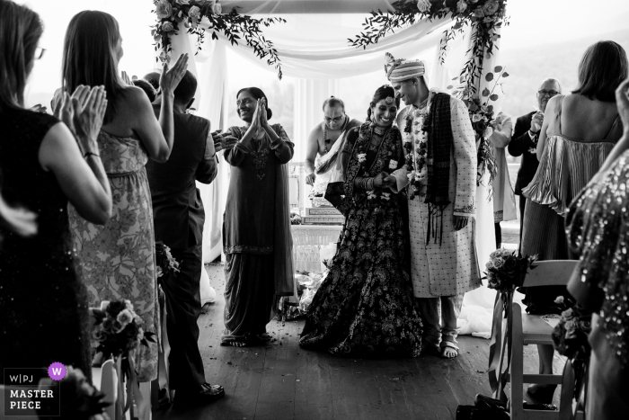 A top documentary wedding photographer from New Hampshire created this image at the Omni Mount Washington Resort in Bretton Woods of The newlyweds announced to their family and friends at the end of the Indian wedding ceremony