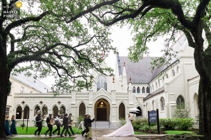 A wedding photojournalist in New Orelans captured this moment at Maison Perrier of A wedding party celebrating with a second line on a rainy day A wedding photojournalist in New Orelans captured this moment at Maison Perrier of A wedding party celebrating with a second line on a rainy day