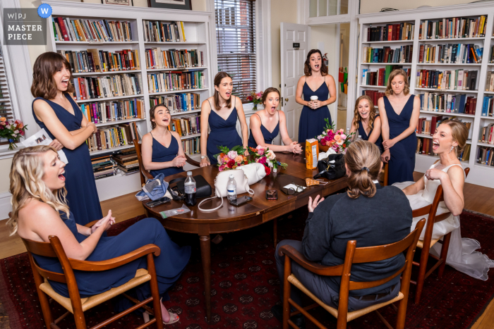 Ein führender dokumentarischer Hochzeitsfotograf in der St. Paul's Memorial Church in Charlottesville, VA, hat dieses Bild erstellt, das Braut und Brautjungfern zeigt, die alle auf eine Geschichte des Amtsträgers reagieren