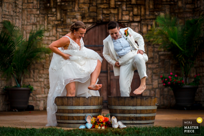 Brittany Diliberto aus Virginia hat dieses Hochzeitsfoto aufgenommen Zwei Bräute, die an ihrem Hochzeitstag in der Potomac Point Winery, Stafford VA . Trauben stampfen