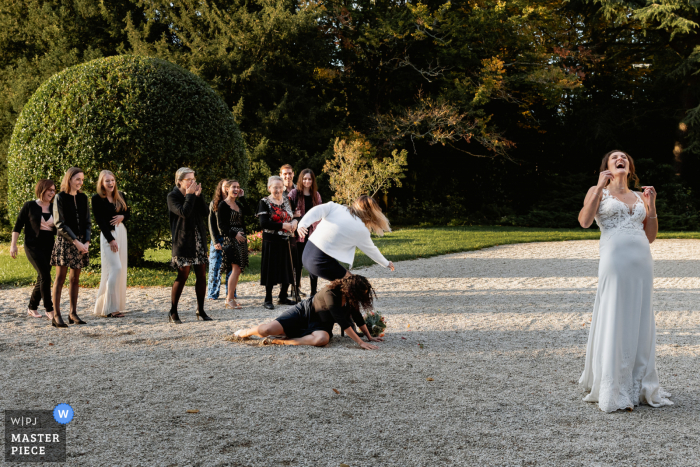 Sehen Sie sich dieses humorvolle Pariser Hochzeitsbild von einem Empfangsort im Freien an, auf dem die Frauen beim Blumenstraußwerfen zu sehen sind