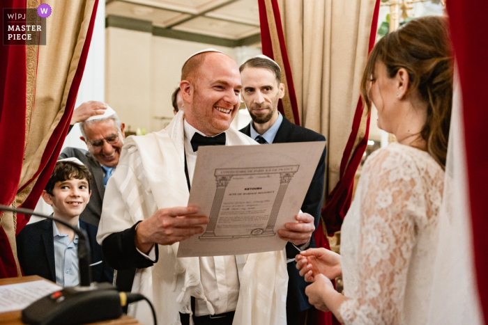 Un'immagine del matrimonio in stile documentario parigino che mostra un momento nel luogo della cerimonia durante una cerimonia ebraica