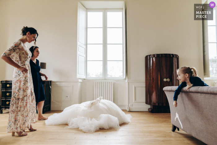 Melhor foto de casamento documental de Haute Vienne do Chateau Laplaud, Oradour sur Glane mostrando A filha da noiva acaba de cometer um erro com o vestido de sua mãe na frente das testemunhas