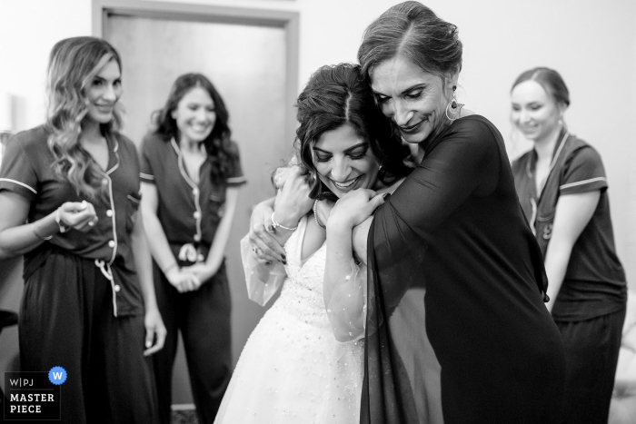 Easthampton, Massachusetts wedding reportage photojournalist created this image at The Boylston Rooms showing the bride and her mother embracing