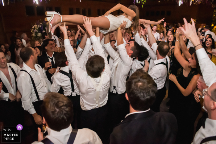 Beste Aspen-fotojournalistiek voor bruiloften van Chapperral Ranch in Colorado die laat zien dat de bruid wordt gedragen door bruiloftsgasten tijdens de huwelijksreceptie