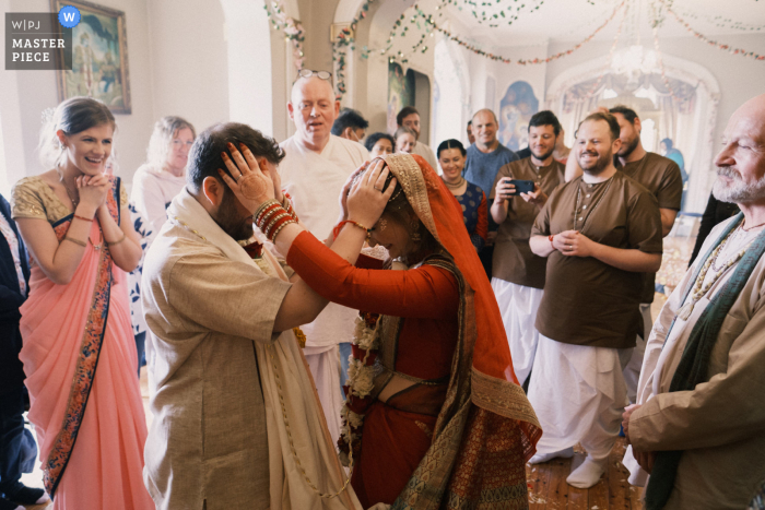 A top Northern Ireland wedding photographer captured this picture at Hare Krishna Island showing The bride and groom gently holding one anothers heads, symbolically, towards the end of the ceremony A top Northern Ireland wedding photographer captured this picture at Hare Krishna Island showing The bride and groom gently holding one anothers heads, symbolically, towards the end of the ceremony