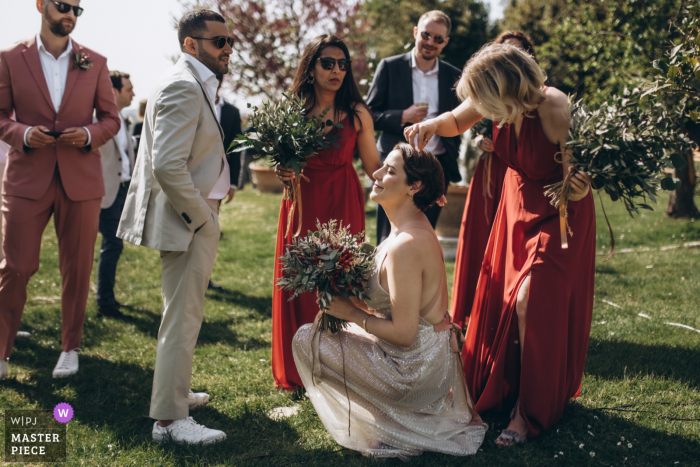 Immagine del matrimonio in Toscana dalla location del matrimonio di Villa Catignano che mostra la sposa che ha bisogno di aiuto