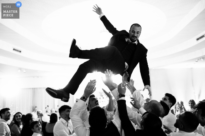 Documentary wedding photographer at Vale da Corga event venue in Trofa, Portugal captured the Friends of the groom gathered, and upon entering the dining room, they shot him into the air