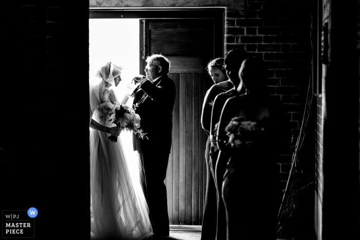 Geelong, Victoria BW imagen de la boda de Grammar Church en Australia que muestra al padre de la novia cubriendo el rostro de su hija con el velo