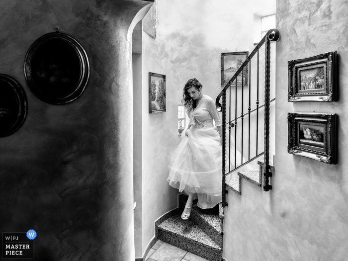 Fotografia de casamento de Cuvry, França da noiva descendo as escadas de sua casa para ir à cerimônia