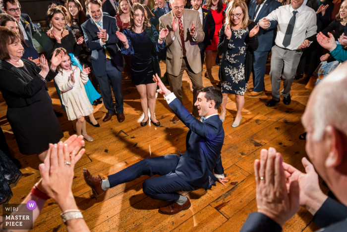 Fotografia documentaria dal Riverside sul luogo del matrimonio Potomac a Leesburg, in Virginia, che mostra uno sposo che balla sul pavimento durante l'Hora