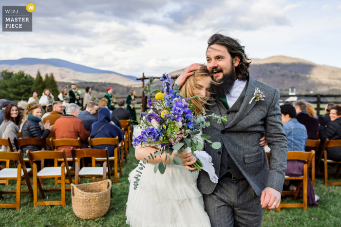 Montfair Resort Farm wedding venue photography in Charlottesville, Virginia capturing Couple joyfully recessing from their ceremony on a very windy day