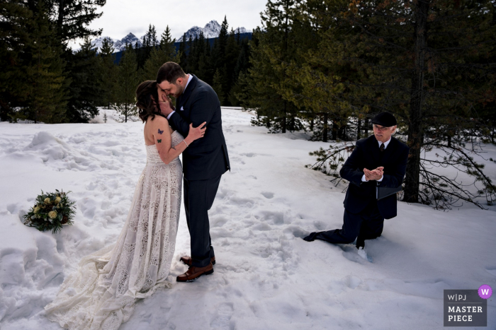 Fotografia documental de um local de fuga de casamento em Banff, criado quando o comissário cai na neve profunda durante a cerimônia de casamento Fotografia documental de um local de fuga de casamento em Banff, criado quando o comissário cai na neve profunda durante a cerimônia de casamento