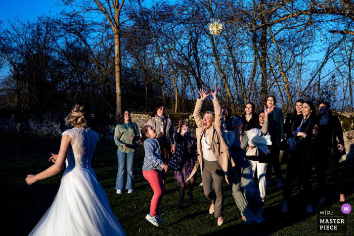 Immagine del matrimonio Nievre da una location per matrimoni in Francia che mostra il lancio del bouquet da parte della sposa all'aperto