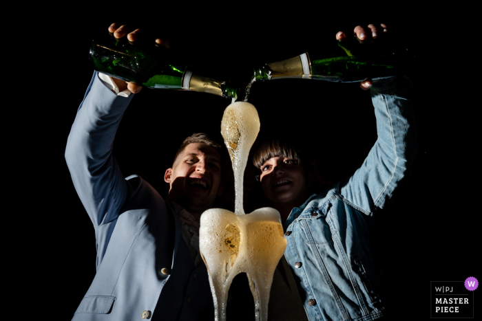 Lyon, France based wedding and event photography of the Champagne tower pour by bride and groom