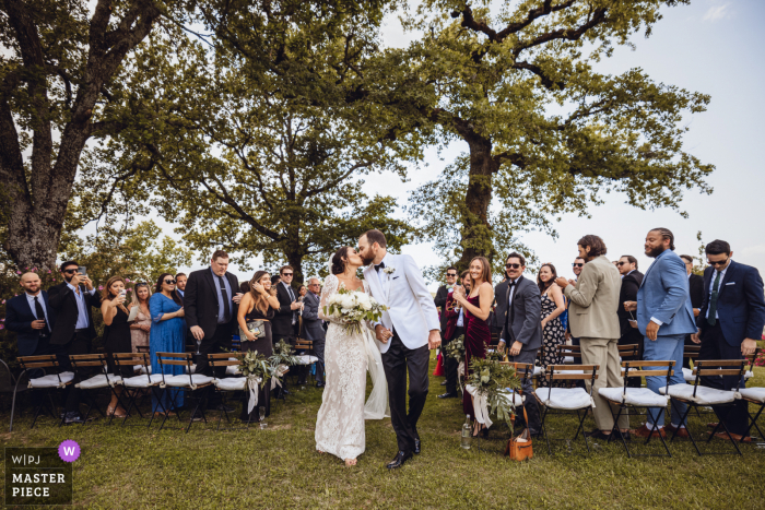 Melhor fotografia de casamento em Siena no Castello di Meleto mostrando a noiva e o noivo deixando a cerimônia imediatamente após o sim Melhor fotografia de casamento em Siena no Castello di Meleto mostrando a noiva e o noivo deixando a cerimônia imediatamente após o sim