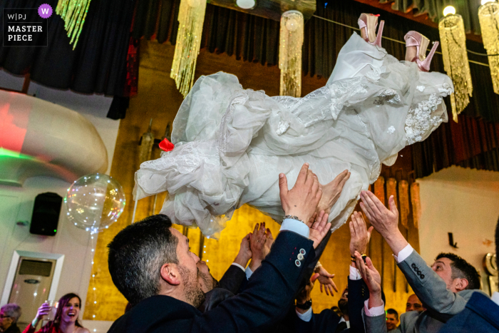 Der dokumentarische Hochzeitsfotograf am Veranstaltungsort des Hotel ACG Los Villares in Jaen, Spanien, hielt die Braut fest, die auf der Hochzeitsfeier in die Luft geschleudert wurde