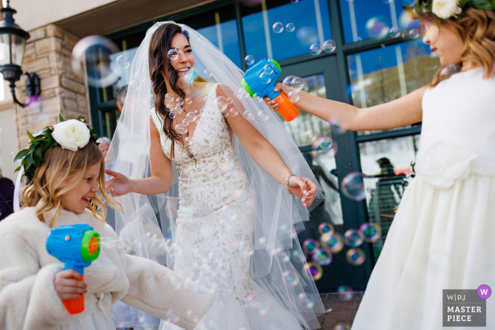 Park Hyatt Beaver Creek imagen de boda de un lugar de celebración de bodas en Colorado de niñas de las flores disfrutan celebrando a la madre con burbujas Park Hyatt Beaver Creek imagen de boda de un lugar de celebración de bodas en Colorado de niñas de las flores disfrutan celebrando a la madre con burbujas