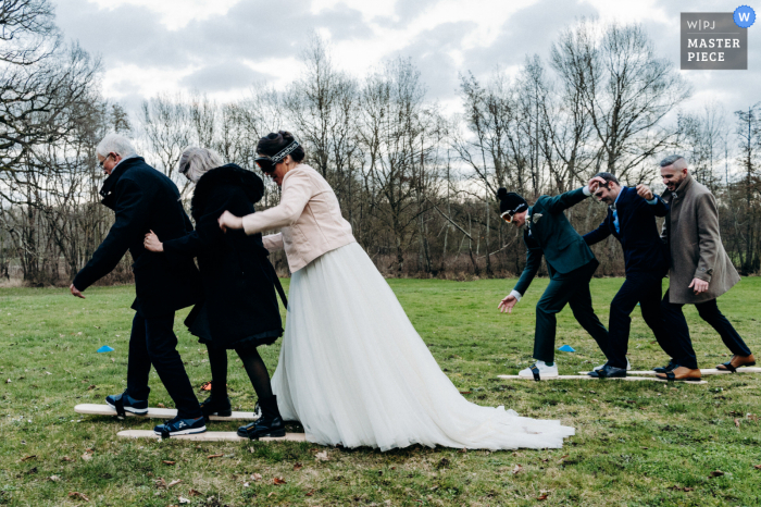 Domaine de l'Hôtel-Noble Hochzeitsfotografie in Vernou-sur-Brenne, Frankreich, die Braut und Bräutigam beim gemeinsamen Skifahren mit ihren Gästen einfängt