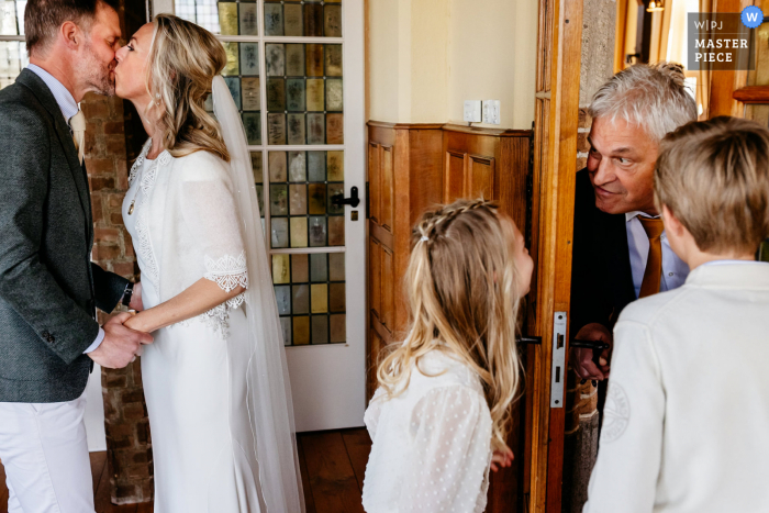 Vught, Netherlands based wedding and event photography created after the ceremony as the couple is together with their kids, when dad comes walking in