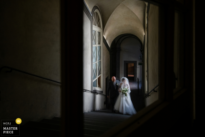 Fotografia documental de um local de casamento em Florença, Itália, capturando a noiva com seu pai entrando na cerimônia