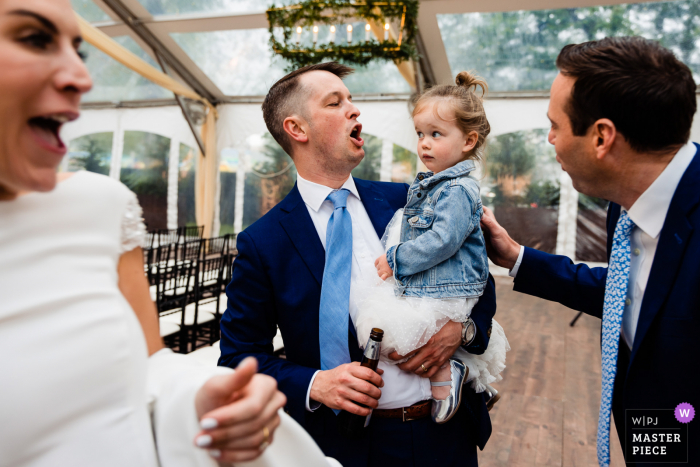 Best wedding photography from a Philadelphia venue showing Bride, groom, and the grooms brother are all getting pumped up for the ceremony while the flower girl isnt quite sure why everyone is yelling