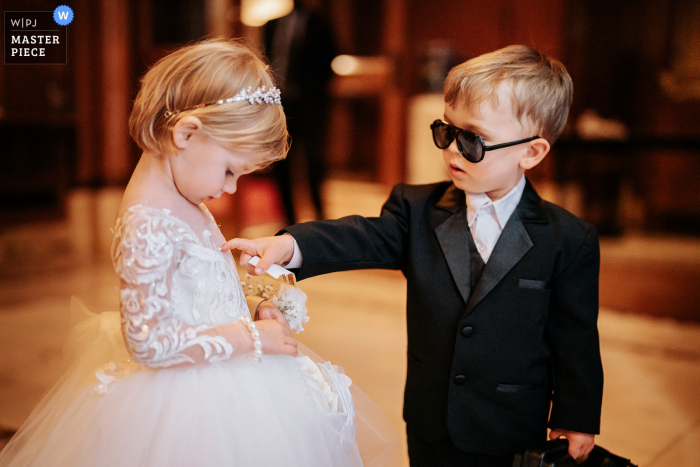 Documentaire trouwfotograaf in de Fifth Avenue Presbyterian Church van de bruidsfeestkinderen die hun formele kleding inspecteren