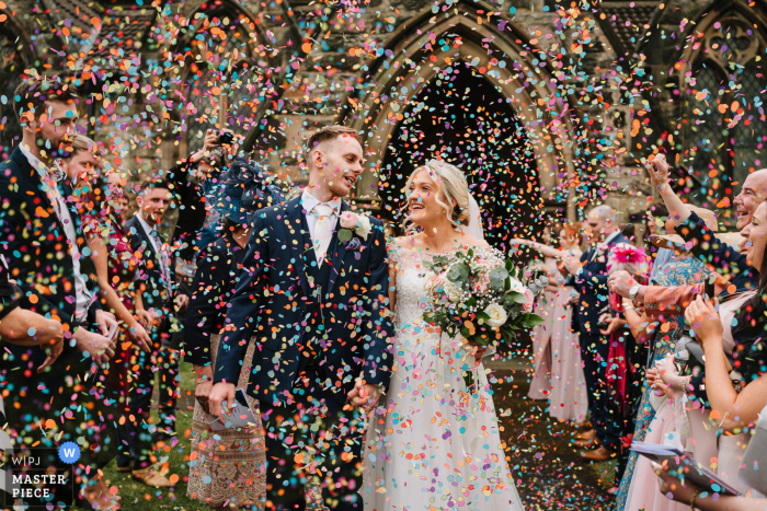 Photographie documentaire du lieu de mariage Shrigley Hall à Macclesfield, Cheshire, Royaume-Uni montrant une sortie extérieure de confettis pour la mariée et le marié