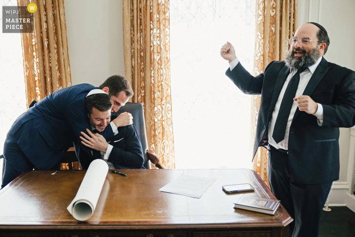 Beste trouwlocatiefotografie in Massachusetts op de Pierce Farm in Witch Hill, die de handtekening van Ketubah met een knuffel vastlegt