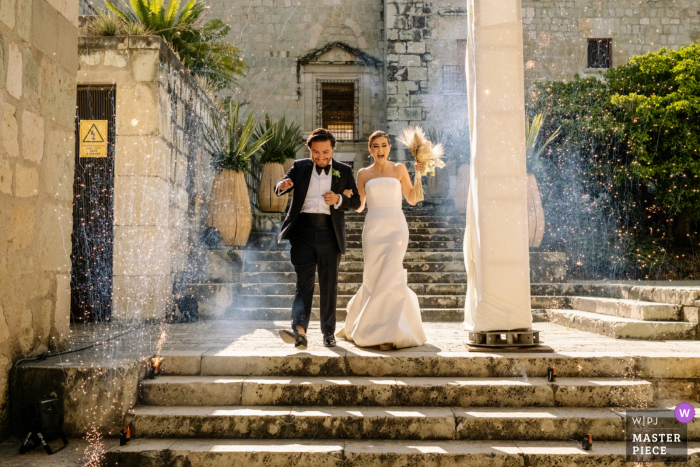 La mejor fotografía del lugar de la boda en la ciudad de Oaxaca en el Jardín Etnobotánico de la novia y el novio llegando a la recepción de su boda