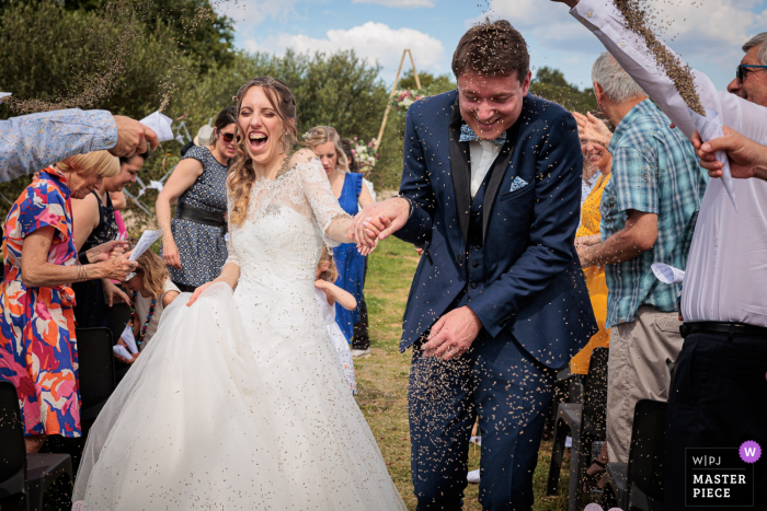 Fotografía de bodas y eventos de Château De Massillan en Vaucluse, sur de Francia, al final de la ceremonia, mientras los recién casados ​​cruzan el pasillo y los invitados les arrojan lavanda.