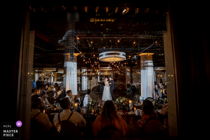 Fotografía del lugar de la boda River Roast en Chicago desde el primer baile a través de una ventana