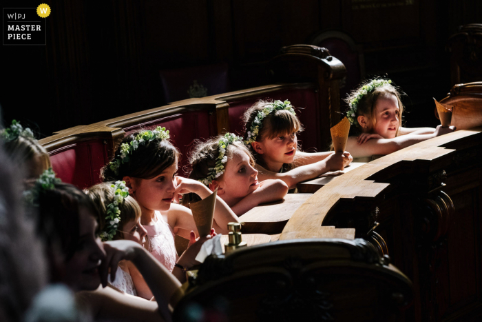 Trouwkerkfotografie in Londen in goed licht met bloemenmeisjes die naar de ceremonie kijken