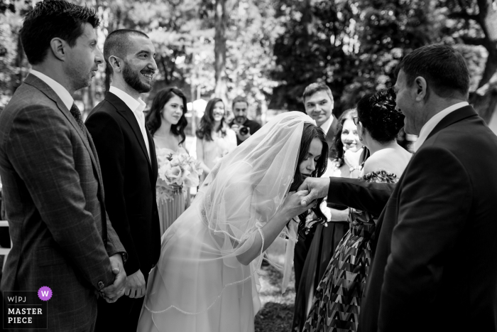 Loft Diplomat wedding venue photography in Bucharest, Romania of Bride kissing her mother in law hand at the end of the orthodox ceremony