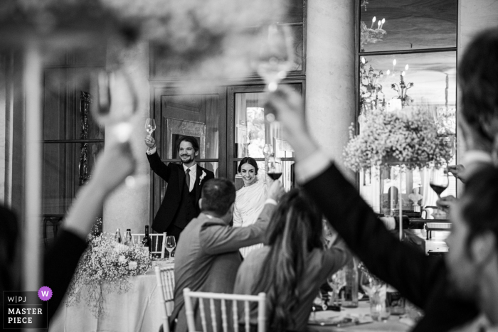 Fotografía documental en blanco y negro de un lugar de celebración de bodas en Filottrano de los novios bebiendo brindis