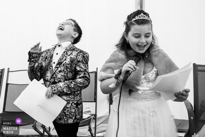 Fotógrafo de bodas documental BW en Vosges capturó al hijo y la hija de los novios riéndose durante sus discursos