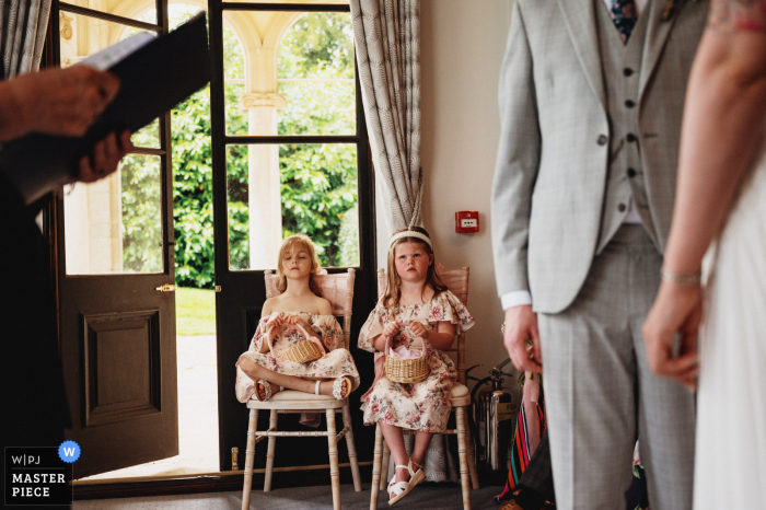 Best wedding photography from a Rugby venue, Bourton Hall of Tired flower girls during the ceremony