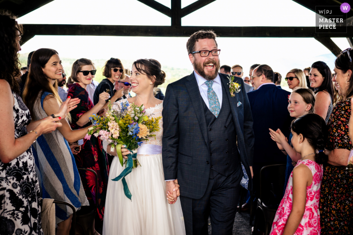 Dokumentalny fotograf ślubny w The Barn at Boyden Farm w Vermont uchwycony Nowożeńcy wycofują się z ceremonii