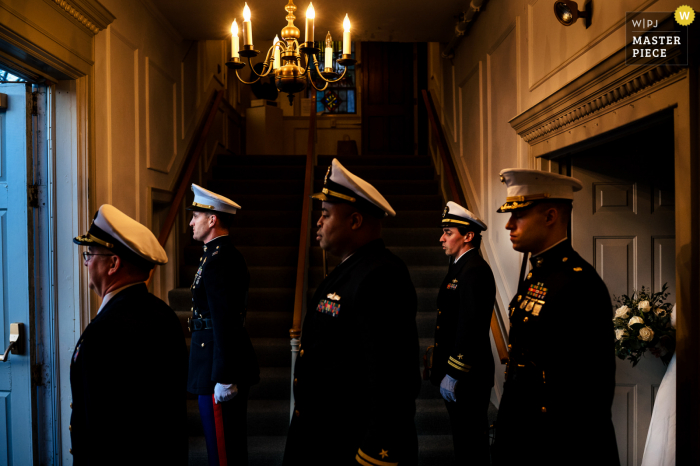 Hochzeits- und Eventfotografie aus Manchester Vermont im Equinox Resort, die militärische Trauzeugen zeigt, die den Navy-Schwertbogen für den Ausgang des Brautpaars vorbereiten