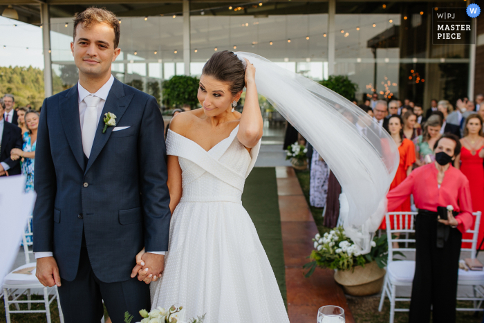 Beste Bento Goncalves-Hochzeitsfotografie bei Marco Luigi, die den fliegenden Schleier der Braut während der Zeremonie einfängt