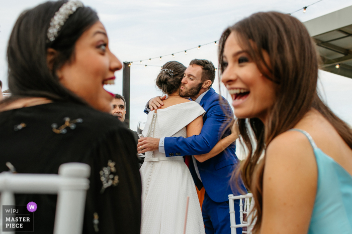 La migliore fotografia del luogo di matrimonio di Marco Luigi a Bento Goncalves che cattura gli ospiti che ridono mentre la sposa abbraccia l'altro ospite