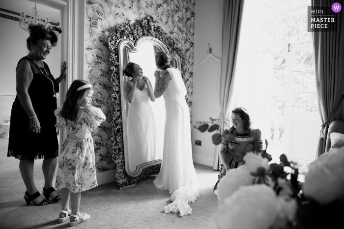 Fotógrafo de casamento documental no local do evento Bourton Hall em Rugby, Reino Unido, capturou a noiva se preparando na frente de um espelho