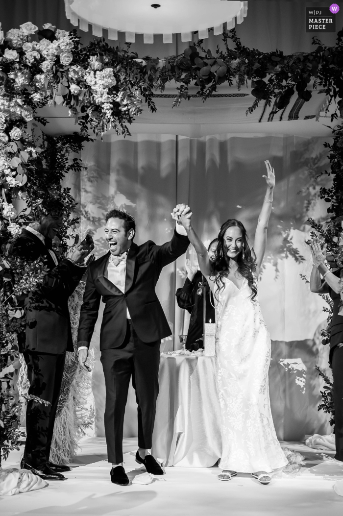 World class documentary wedding photography at the Polo Club in Boca Raton in Florida of the bride & grooms excited response after being announced as husband and wife